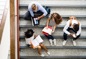 Schüler sitzen auf Treppe und diskutieren